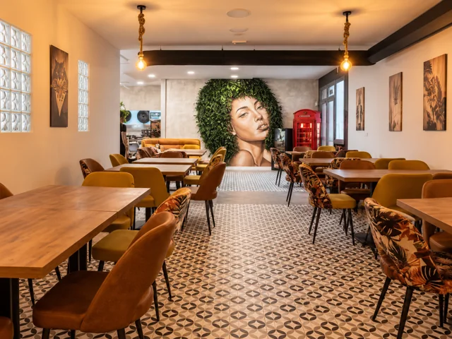Sala de Cruza la Raya con mesas de madera y mural vegetal